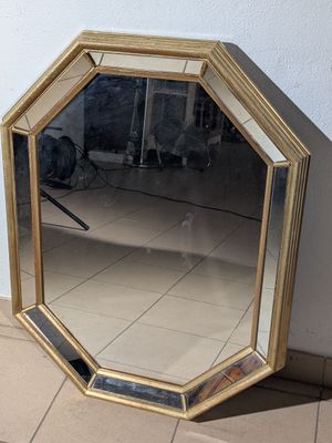 un miroir posé par terre près d'un mur