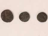 three ancient roman coins sitting side by side on a white surface