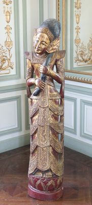 une statue représentant une femme debout dans une pièce