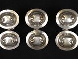four silver plated knobs on a black background
