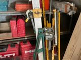 un tas d'outils dans un garage, à côté d'une étagère