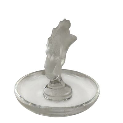 a glass candle holder with a statue of a hand on it