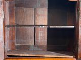 an old wooden cabinet with a glass door on top of it