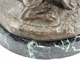 a statue of a dog that is sitting on a marble base