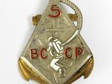 the badge of a baseball player holding a bat on a white surface