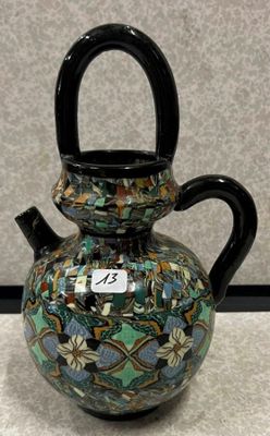 un vase muni d'une anse, posé sur une table