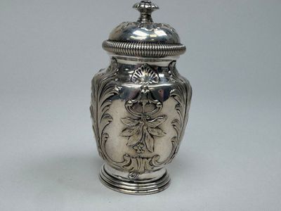 un vase en argent muni d'un couvercle, posé sur une table
