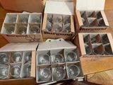 des cartons de verres à vin vides posés sur une table, à côté d'un carton de verres à vin vides
