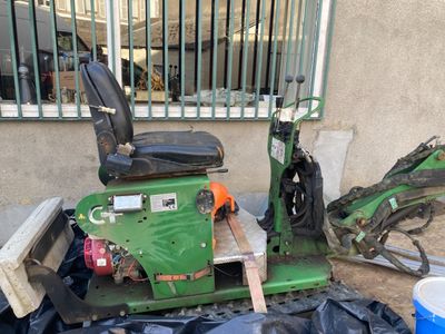 a green scooter parked next to a trash can