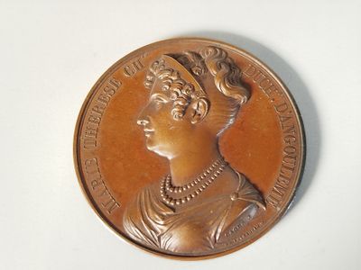 une médaille de bronze sur laquelle est représenté le visage d'une femme