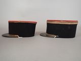 pair of black hats with red trims sitting on top of each other