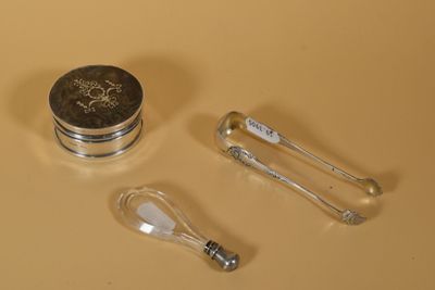 un récipient en argent avec une cuillère et un repose-cuillère à côté