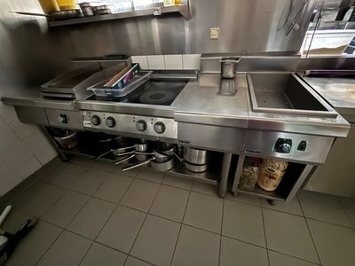 une cuisine équipée d'une cuisinière, d'un évier et de casseroles et poêles