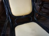 une chaise noire avec une assise jaune et un coussin blanc