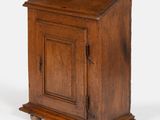 une vieille armoire en bois avec une porte et un tiroir au-dessus