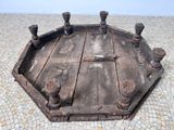 an old wooden tray on the ground with a cross on it