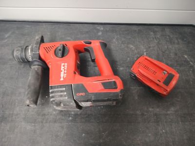 a corded drill and a battery on the floor