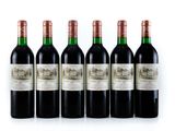 six bottles of red wine lined up in a row on a white surface