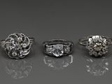 trois types différents de bagues en diamant posées sur une surface réfléchissante