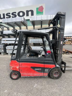 a red fork truck parked in front of a building