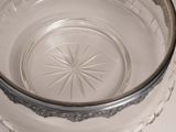 a glass bowl with a silver rim on a white table