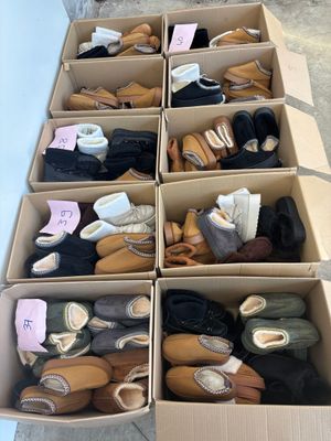 plusieurs paires de chaussures dans une boîte posée sur le sol