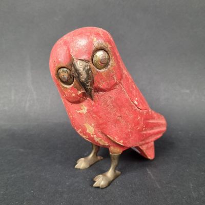 a small red bird that is sitting on a table