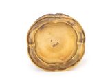 an antique gold plate with a flower design on it