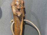 a statue of a man holding a cane with a rope around it