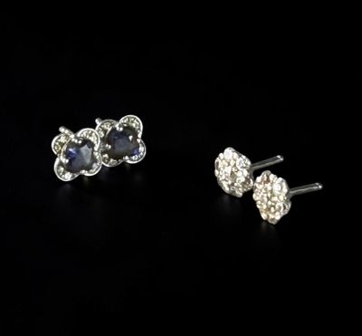 a pair of sapphire and diamond earrings on a black background