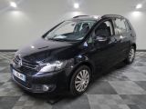 La Volkswagen Touran noire est garée sur un sol en carrelage à damier.