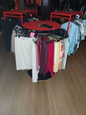 beaucoup de vêtements suspendus à une étagère dans un magasin