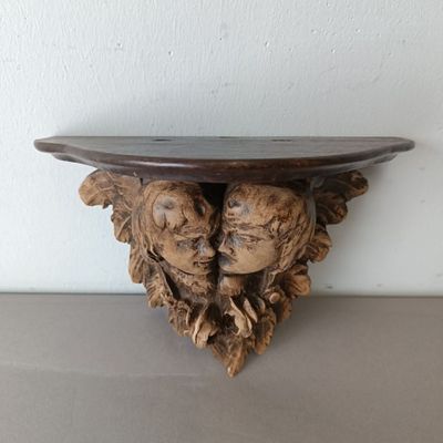 a wooden shelf that has two heads on it