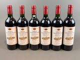 six bouteilles de vin rouge alignées sur une table