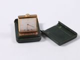 a small square clock sitting on top of a small box