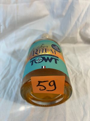 a bottle of liquid sitting on a bed with a price tag on it