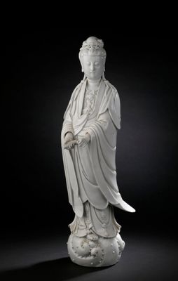 an image of a statue of a woman sitting on top of a rock