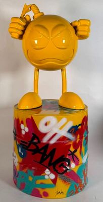 un jouet jaune posé sur une boîte recouverte de graffitis