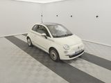 une Fiat blanche garée dans un garage dont le sol est recouvert d'un motif à carreaux noirs et blancs