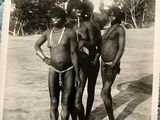 three men standing next to each other on a beach