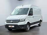 La camionnette blanche est garée dans une pièce blanche au sol noir.