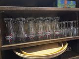 une étagère en bois sur laquelle se trouvent de nombreux verres et assiettes vides