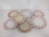 six red and white plates with designs on them sitting on a table