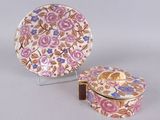une paire d'assiettes en porcelaine et une boîte décorative posée sur un socle