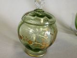 two green glass jars with gold designs on them
