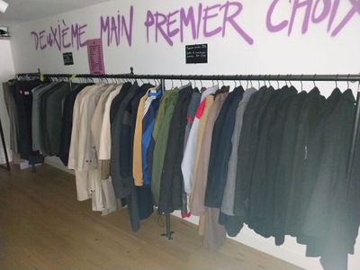 beaucoup de vêtements suspendus à une étagère dans une pièce