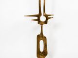 brass sculpture of a fork and a knife on a white background