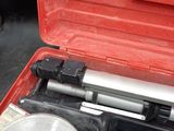 a tool in a red case that is sitting on the floor
