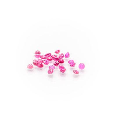 a pile of pink glass beads on a white surface