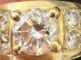 a close up of a gold ring with a diamond on it